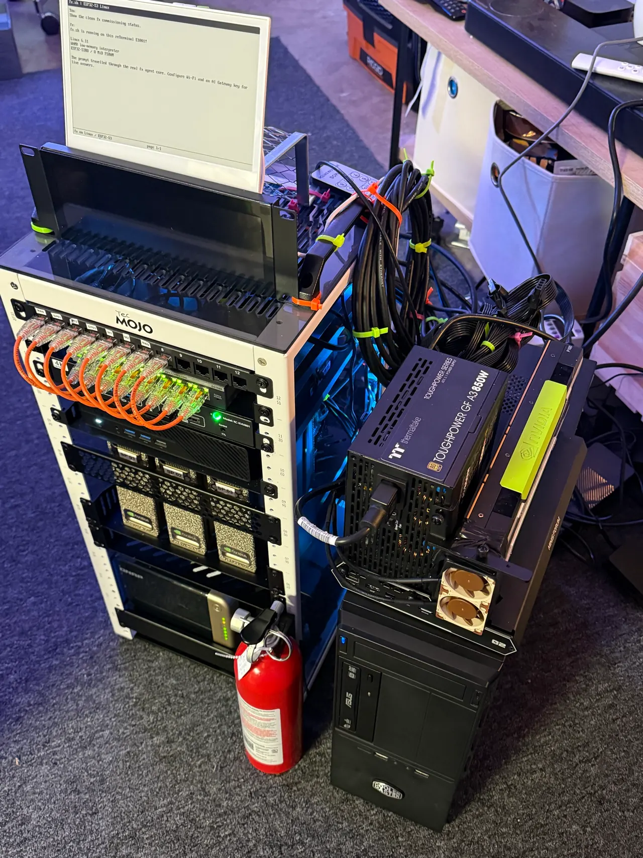 The assembled Hackers in the Loop mini rack with three DGX Sparks, network cabling, storage, and an external GPU bench.